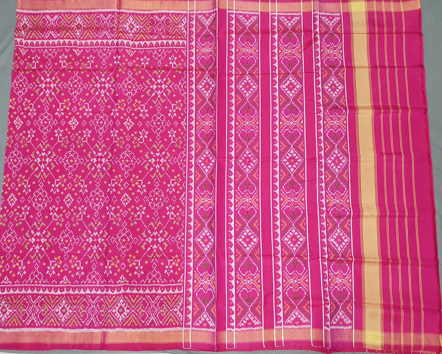 Pink fabric with intricate patterns on a gray background