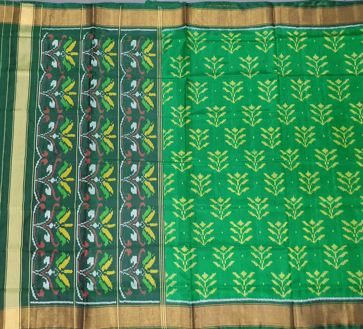 Green saree with floral patterns on a gray background