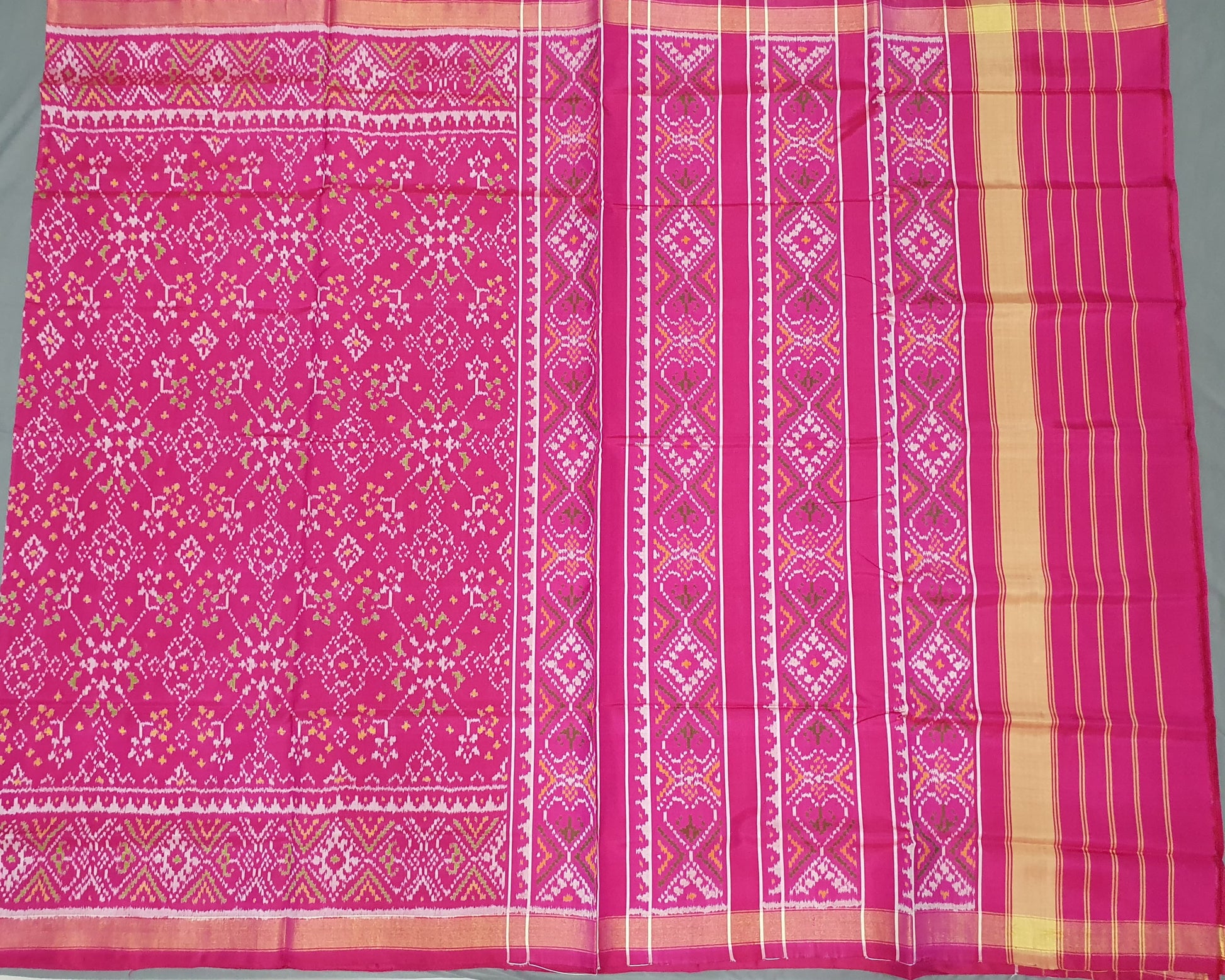 Pink fabric with intricate patterns on a gray background